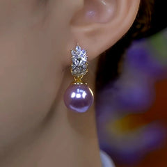 Side close-up of purple pearl crystal drop earring worn on a woman's ear