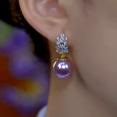 Front close-up of purple pearl crystal drop earring worn on ear