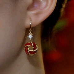 Model showcasing the dangle and style of the 14K Gold-Plated Zircon Red Ball Earrings
