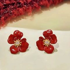 Angled view of the 14K Gold-Plated Zircon Red Glaze Flower Stud Earrings