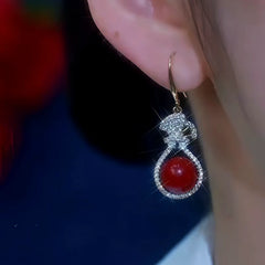 Model showcasing the dangle and style of the 14K Gold-Plated Zircon Red Pearl Ear Hook Earrings