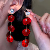 Red rose petal crystal stud long drop earrings, one worn on ear, one held for display