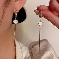 Model showcasing the dangle and style of the 14K Gold-Plated Zircon Round Plate Tassel Earrings