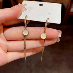 Angled view of the 14K Gold-Plated Zircon Round Plate Tassel Earrings
