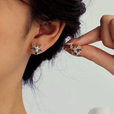 Rose gold pave CZ fox head stud earrings, one worn on ear, one held in hand