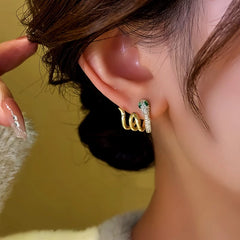 Close-up detail of the sparkling zircons and plating on the Snake Stud Earrings