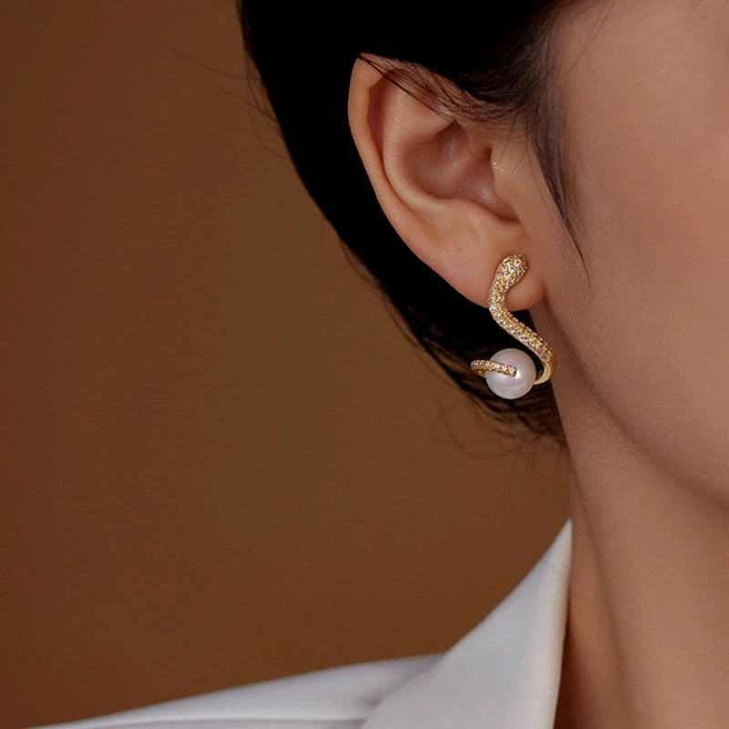 Model showcasing the dangle and style of the 14K Gold-Plated Zircon Snake Pearl Earrings