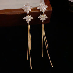 Model showcasing the dangle and style of the 14K Gold-Plated Zircon Snowflake Long Tassel Earrings