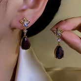 Women's Gold Flower Dark Purple Teardrop Crystal Dangle Earrings on Ear