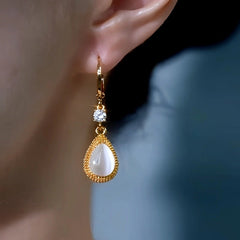 Model showcasing the dangle and style of the 14K Gold-Plated Zircon White Cat's Eye Stone Water Drop Earrings