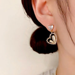 Model showcasing the dangle and style of the 14K Gold-Plated Zircon & Cat's Eye Stone Heart Earrings