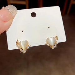 Model showcasing the dangle and style of the 14K Gold-Plated Zircon & Cat's Eye Stone Heart Stud Earrings