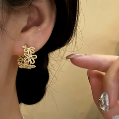 Model showcasing the dangle and style of the 14K Gold-Plated knot Flower C-Shaped Earrings