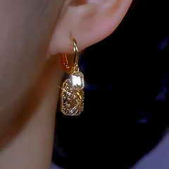 Model showcasing the dangle and style of the 14K Gold-plated Brown Diamond Crystal Square Earrings