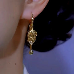 Model showcasing the dangle and style of the 14K Gold-plated Brown Zircon Leaf Earrings