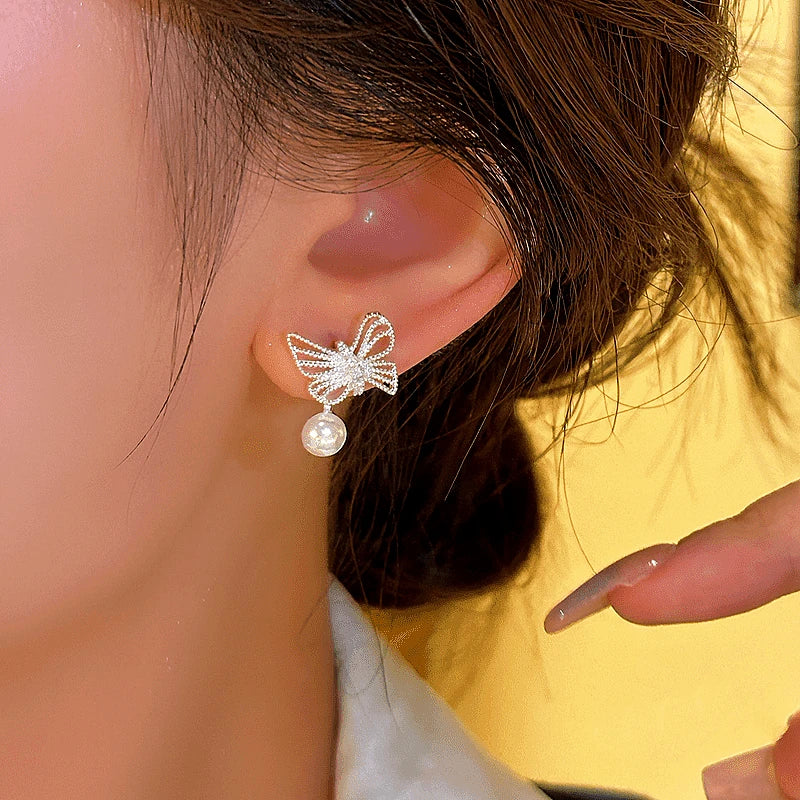 Model showcasing the dangle and style of the 14K Gold-plated Butterfly Bead Earrings