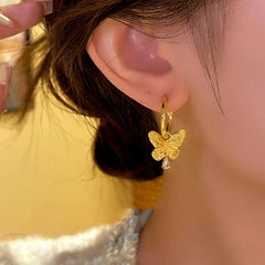 Model showcasing the dangle and style of the 14K Gold-plated Butterfly Pendant Earrings