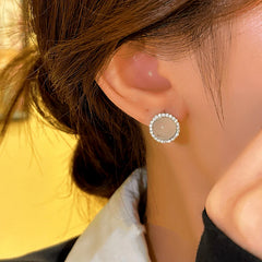 Side angle view of milky white round halo CZ stud earring worn on ear