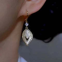 Model showcasing the dangle and style of the 14K Gold-plated Diamond Cat's Eye Leaf Earrings