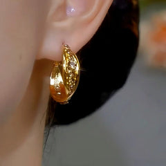 Model showcasing the dangle and style of the 14K Gold-plated Diamond Hoop Earrings