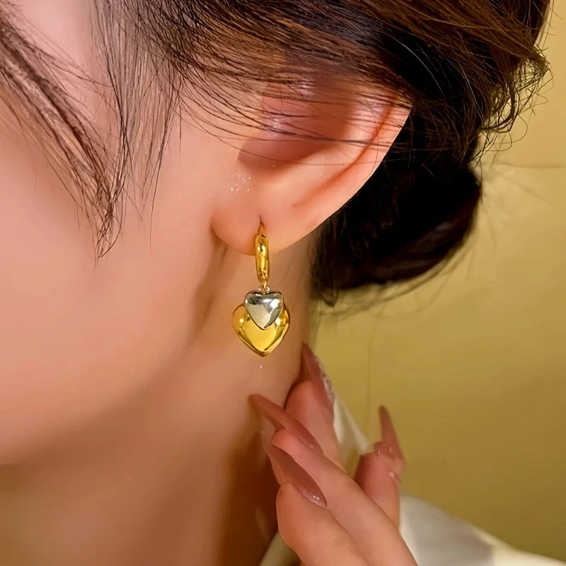 Model showcasing the dangle and style of the 14K Gold-plated Double-Layer Heart Earrings