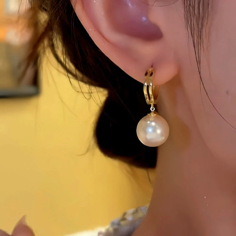 Model showcasing the dangle and style of the 14K Gold-plated Elegant Pearl Earrings