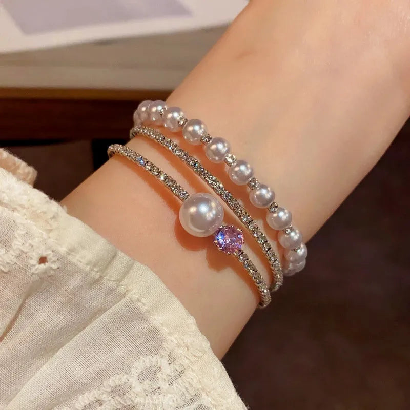 Model wearing the 14K Gold-plated Exquisite Zircon Pearl Stacking Bracelets to highlight its design on the wrist