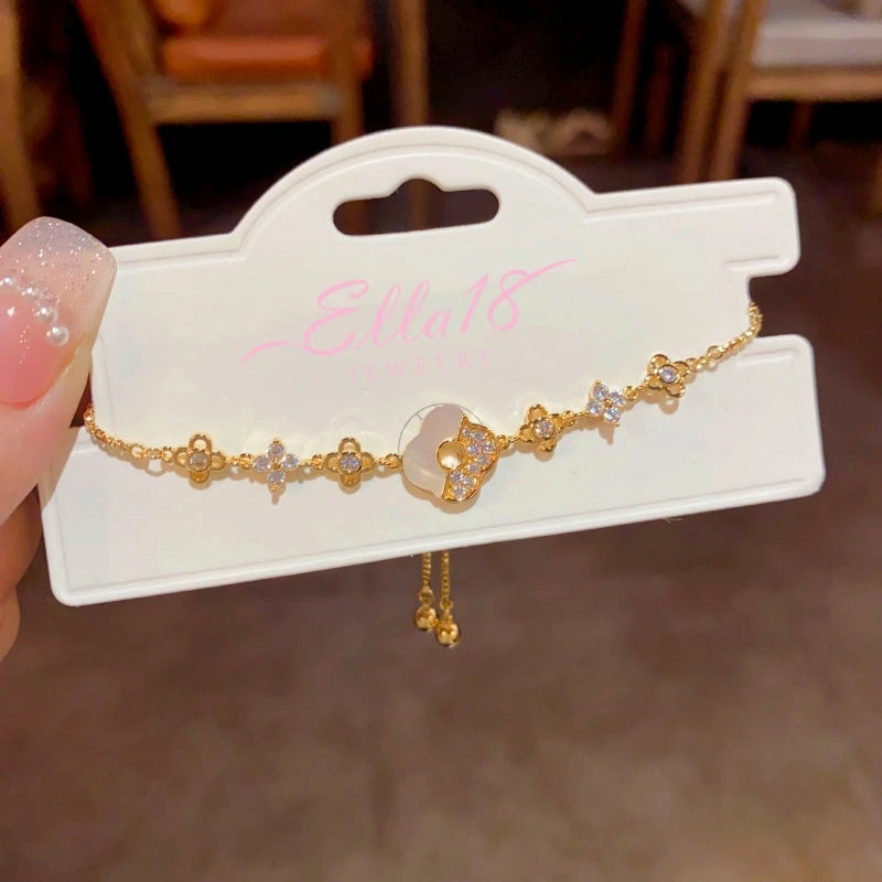 Model wearing the 14K Gold-plated Exquisite Zircon Shell Four-Leaf Flower Bracelet to highlight its design on the wrist