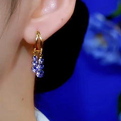 Cascading purple-blue crystal dangle gold hoop earring, on ear side view