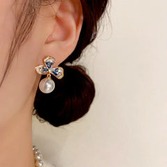 Model showcasing the dangle and style of the 14K Gold-plated Simple Flower Pearl Earrings