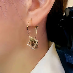 Model showcasing the dangle and style of the 14K Gold-plated Square Crystal Earrings