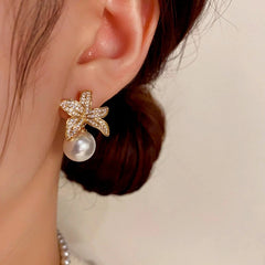 Model showcasing the dangle and style of the 14K Gold-plated Zircon Leaf Pearl Earrings