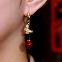 Model showcasing the dangle and style of the 14K Gold Plated Cat's Eye Stone Diamond Butterfly Pearl Earrings