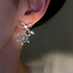 Model showcasing the dangle and style of the 14K Gold Plated Christmas Zircon Snowflake Bow Earrings