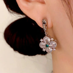 Model showcasing the dangle and style of the 14K Gold Plated Diamond Star Four-Leaf Flower Earrings
