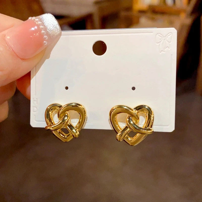 Angled view of the 14K Gold Plated Knotted Love Heart Stud Earrings