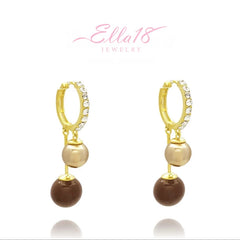 Close-up detail of the sparkling zircons and plating on the gold pearl earrings