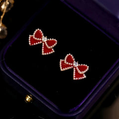 Angled view of the 14K Gold Plated Red Bow Pearl Tassel Earrings