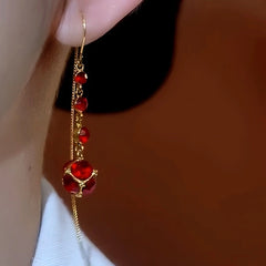 Model showcasing the dangle and style of the 14K Gold Plated Red Crystal Tassel Threader Earrings