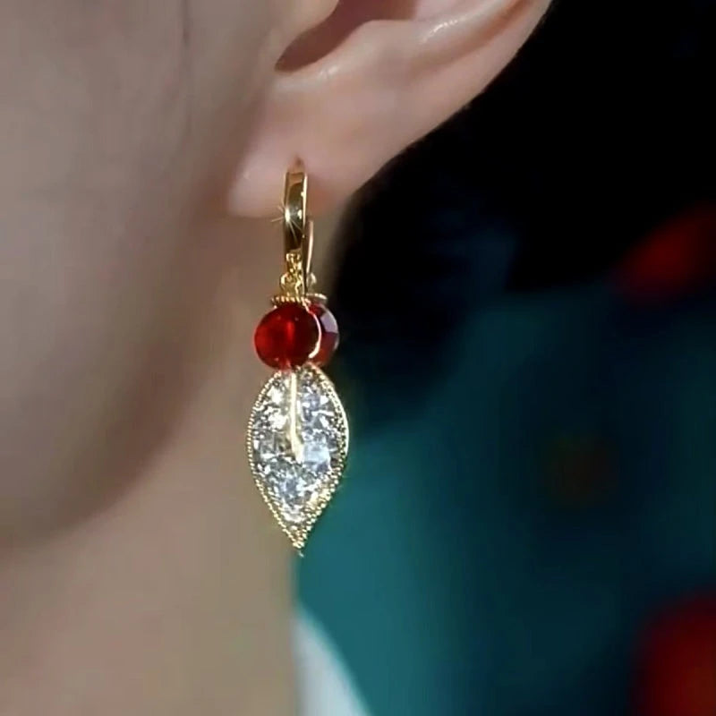 Model showcasing the dangle and style of the 14K Gold Plated Red Diamond Zircon Leaf Earrings
