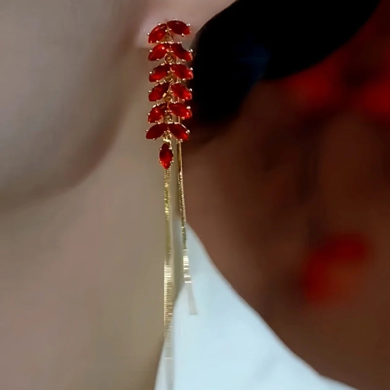 Model showcasing the dangle and style of the 14K Gold Plated Red Wheat Diamond Tassel Earrings