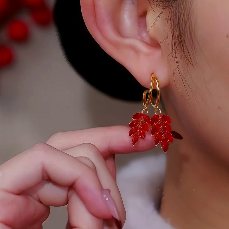 Model showcasing the dangle and style of the 14K Gold Plated Red Zircon Wheat Earrings