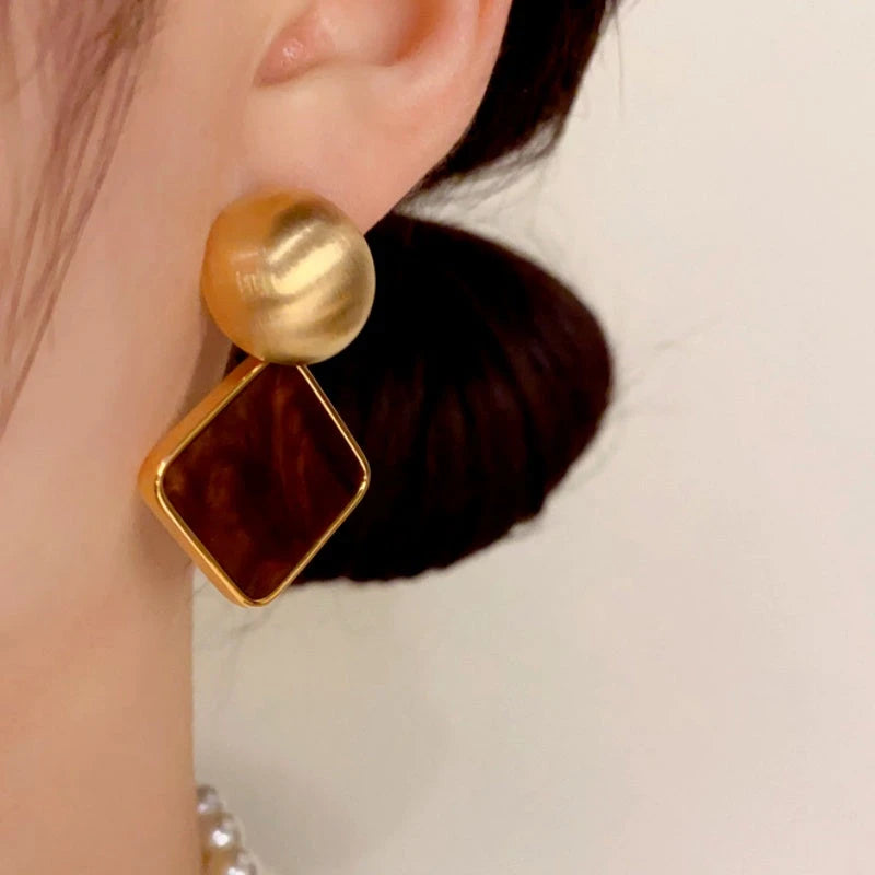 Close-up detail of the sparkling zircons and plating on the gold drop earrings