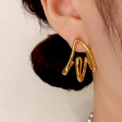 Close-up detail of the sparkling zircons and plating on the gold geometric earrings