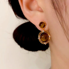 Model showcasing the dangle and style of the 14K Gold Plated Tiger Eye Stone Oval Earrings