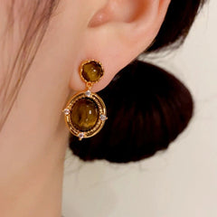 Close-up detail of the sparkling zircons and plating on the gold drop earrings