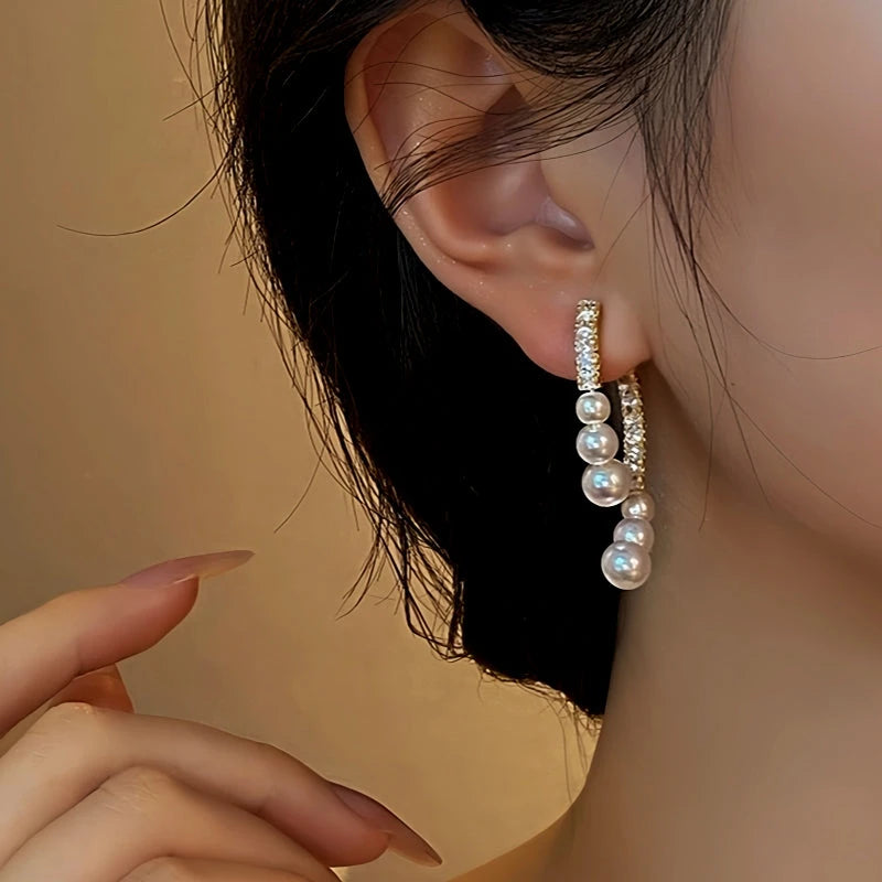 Close-up detail of the sparkling zircons and plating on the gold pearl earrings