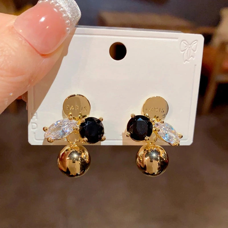 Close-up detail of the sparkling zircons and plating on the gold drop earrings