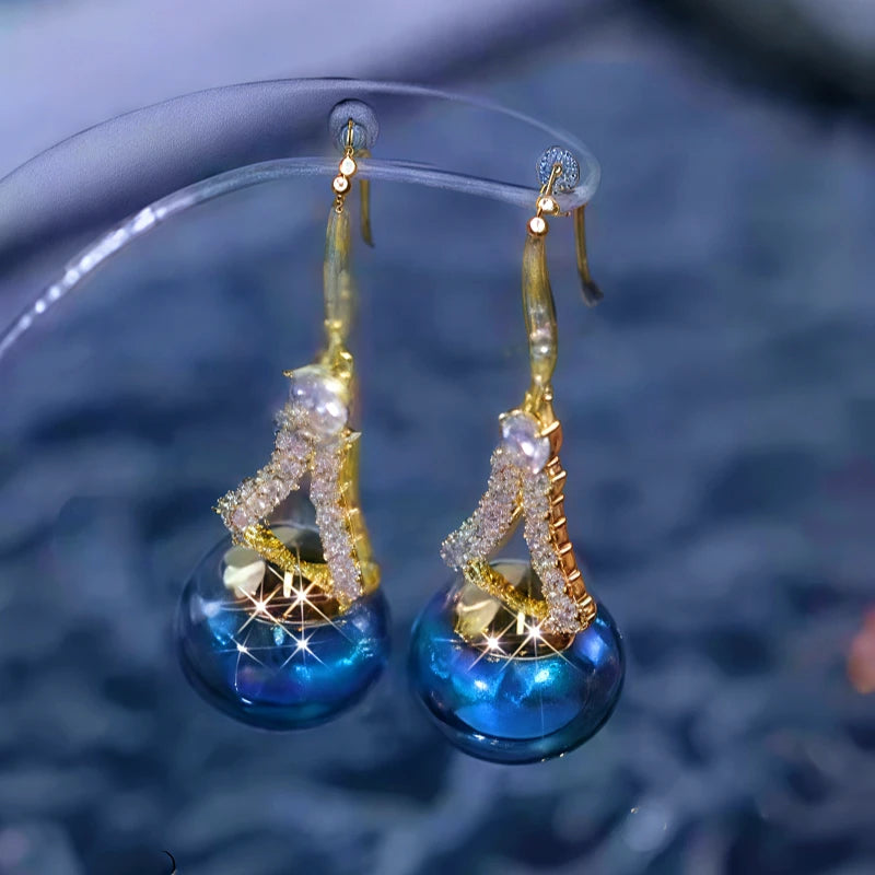 Close-up detail of the sparkling zircons and plating on the gold threader earrings