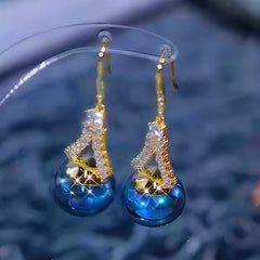 Close-up detail of the sparkling zircons and plating on the gold threader earrings